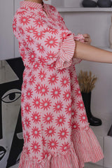 Close-up of pink floral block print on cotton silk with frill hem detail