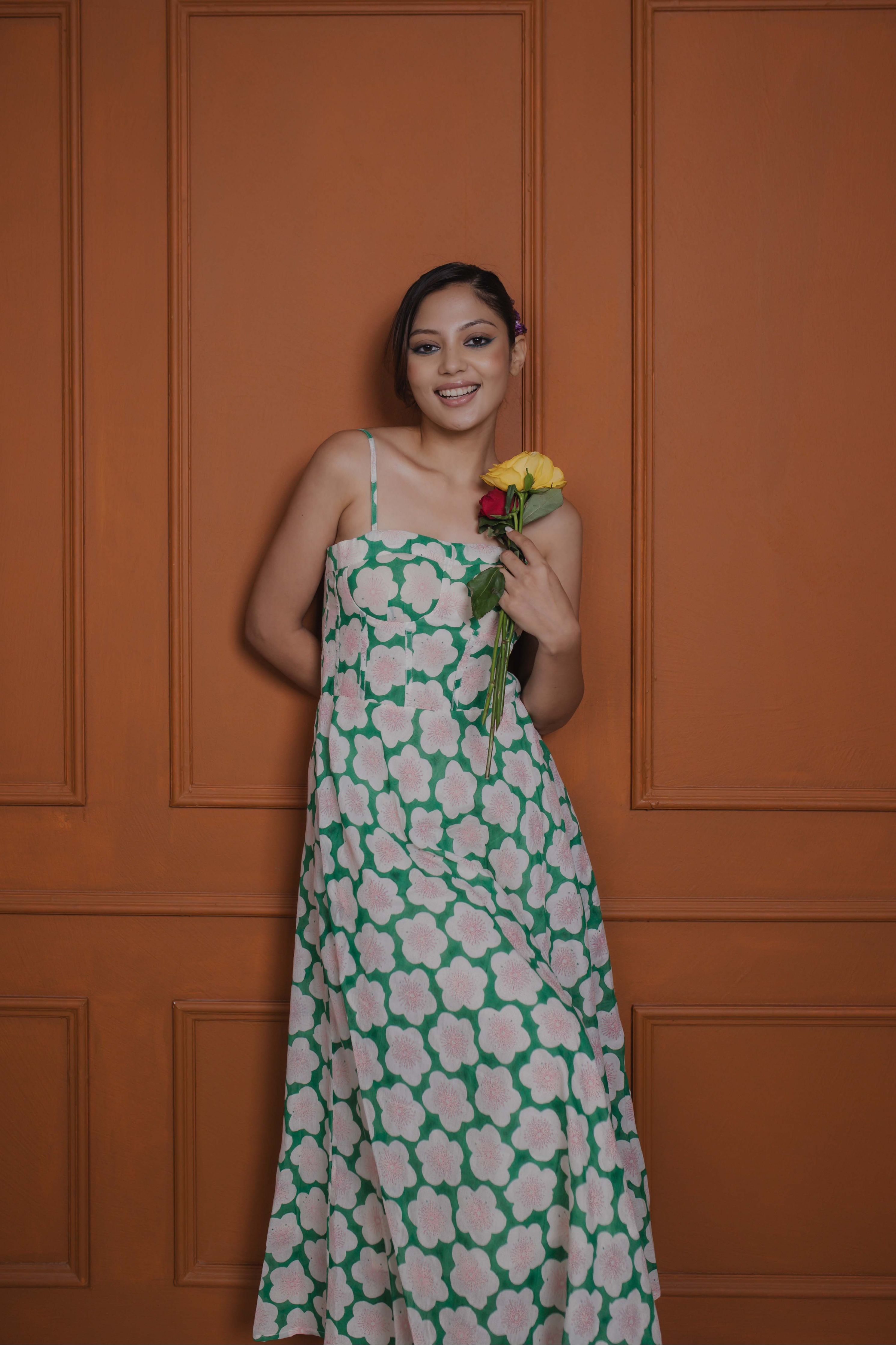 Side profile of green floral midi dress with corset front, adjustable straps, and flowy silhouette